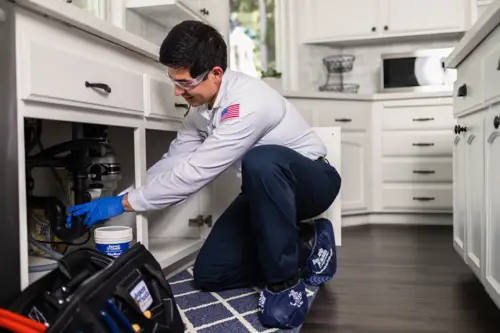 Benjamin Franklin Plumbing Technician, Diego, working under the sink of Pensacola FL home