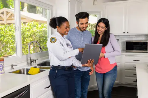 Benjamin Franklin Plumbing Technician, Layla, speaking with homeowners in their Pensacola FL kitchen